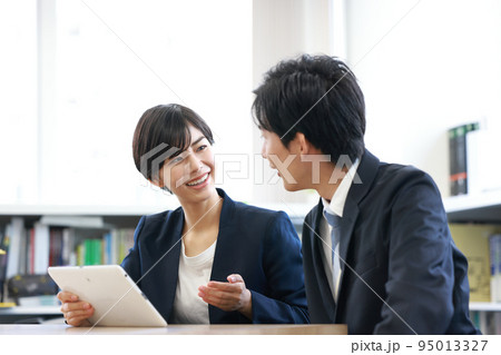 タブレットを見せながら話すビジネスウーマン_1 95013327