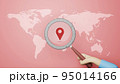 World map with a magnifying glass pointing on red background. 3D illustration 95014166