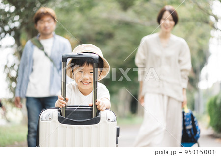 家族旅行・スーツケースを引く子供 95015001