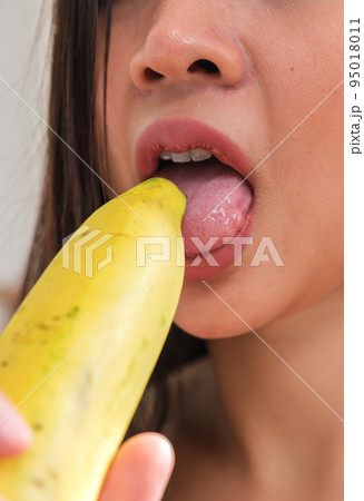 Sexy woman licking yellow banana Sexy woman licking yellow banana 95018011