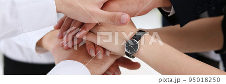Group of people in suits crossed hands in pile Group of people in suits crossed hands in pile 95018250