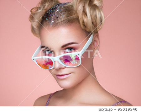 Portrait of beautiful young woman with colored glasses Portrait of beautiful young woman with colored glasses 95019540