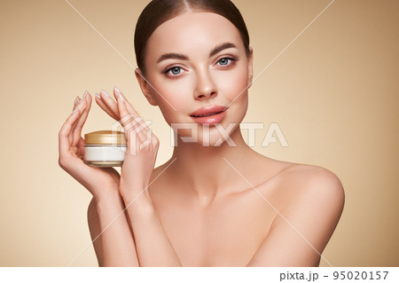 Beauty woman applying cream on her face Beauty woman applying cream on her face 95020157