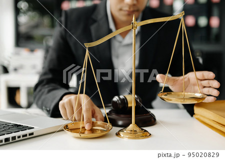 Male lawyer in the office with brass scale on white table. justice and law concept in morning light 95020829