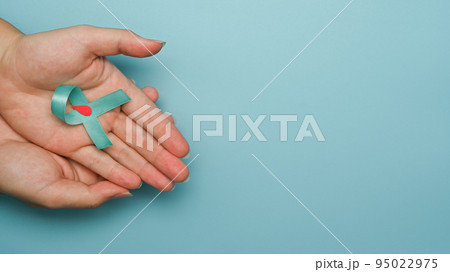 Blue ribbon with a drop of blood in a circle symbol of diabetes day in woman hands. World diabetes day, Copy space 95022975
