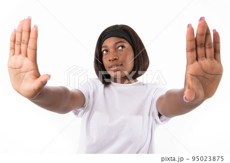 Portrait of smiling young woman making stop or frame gesture 95023875
