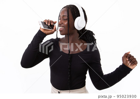 Portrait of happy young woman in headphones recording voice 95023930