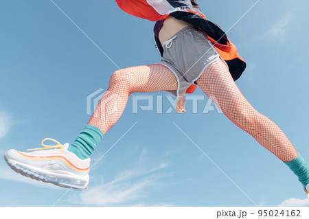 おしゃれなスポーツファッションでジャンプする女性 おしゃれなスポーツファッションでジャンプする女性 95024162