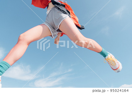 おしゃれなスポーツファッションでジャンプする女性 95024164