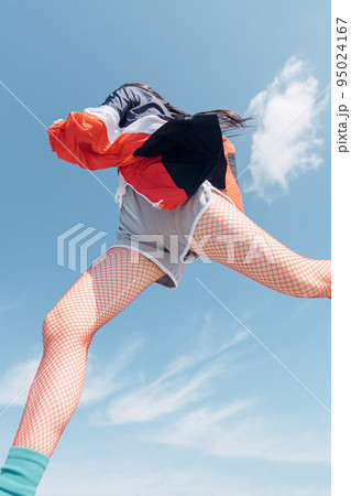 おしゃれなスポーツファッションでジャンプする女性 おしゃれなスポーツファッションでジャンプする女性 95024167