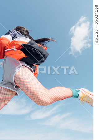 おしゃれなスポーツファッションでジャンプする女性 95024168