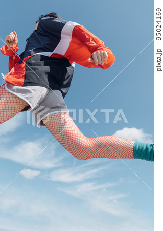 おしゃれなスポーツファッションでジャンプする女性 おしゃれなスポーツファッションでジャンプする女性 95024169