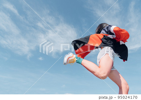 おしゃれなスポーツファッションでジャンプする女性 おしゃれなスポーツファッションでジャンプする女性 95024170