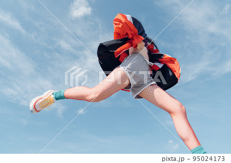 おしゃれなスポーツファッションでジャンプする女性 95024173