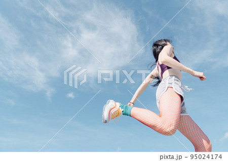 おしゃれなスポーツファッションでジャンプする女性 おしゃれなスポーツファッションでジャンプする女性 95024174