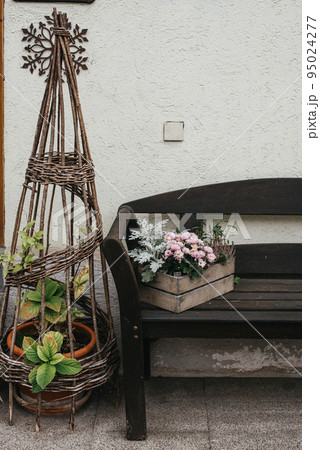 Vintage Outdoor Furniture, Mums And Nik-naks. Wooden Bench In Front Garden With Flower Boxes. Box With Flowers On The Bench. Wooden Bench In Front Garden With Flower Boxes. Box With Flowers On The Vintage Outdoor Furniture, Mums And Nik-naks. Wooden Bench In Front Garden With Flower Boxes. Box With Flowers On The Bench. Wooden Bench In Front Garden With Flower Boxes. Box With Flowers On The 95024277