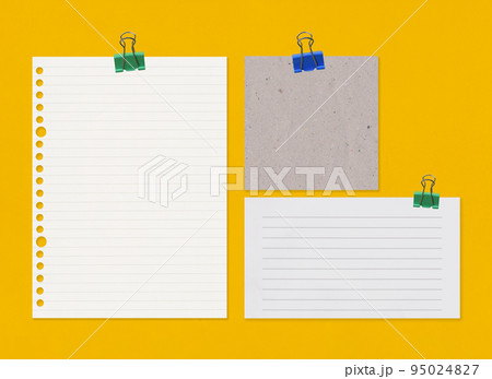 Empty note paper with clip on yellow art paper background. 95024827
