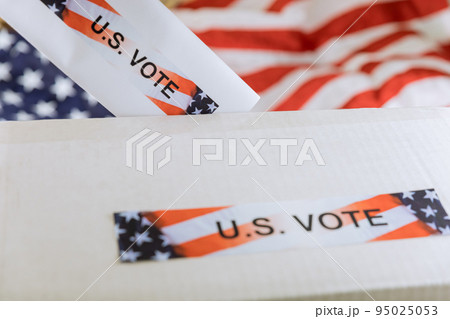An American election ballot box, a USA national flag, and a vote in an American election 95025053