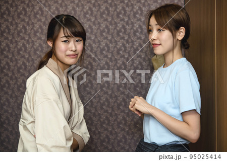 エステ　初めてで困った表情の若い女性とエステティシャン 95025414