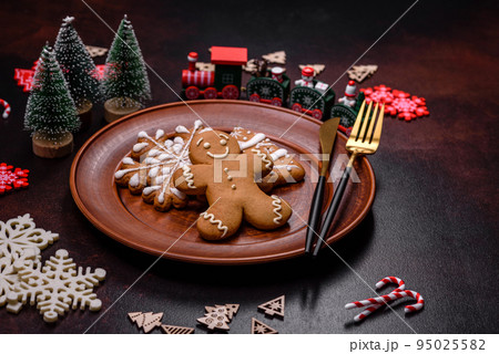 Christmas decoration elements as well as gingerbread on a brown concrete background Christmas decoration elements as well as gingerbread on a brown concrete background 95025582