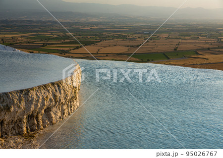 トルコ　ヒエラポリス・パムッカレの夕陽に照らされた石灰棚プール 95026767
