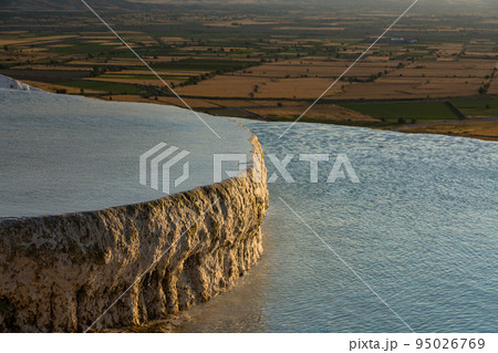 トルコ　ヒエラポリス・パムッカレの夕陽に照らされた石灰棚プール 95026769