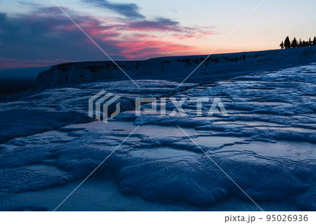 トルコ　夕暮れ時のヒエラポリス・パムッカレの鍾乳石と青い水面 95026936