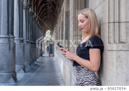 Happy blonde millennial girl in trendy clothes laughing on urban setting during sunny day, positive Happy blonde millennial girl in trendy clothes laughing on urban setting during sunny day, positive 95027054