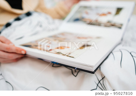 Selective focus and blurry photos. a woman holds a photo book. Selective focus and blurry photos. a woman holds a photo book. 95027810