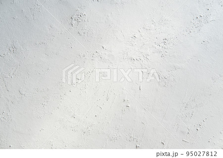 White gray plastered wall background. White concrete background close up. Abrasive white cement background in the rays of the sun with shadows White gray plastered wall background. White concrete background close up. Abrasive white cement background in the rays of the sun with shadows 95027812