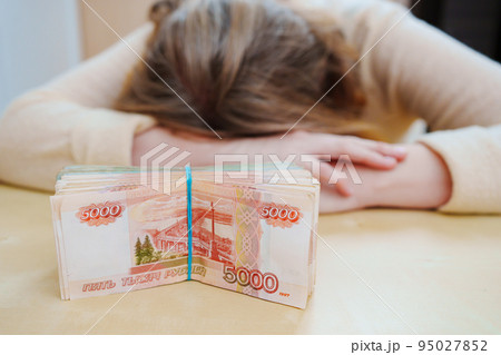 tired woman with a stack of rubles tied with a rubber band. 95027852