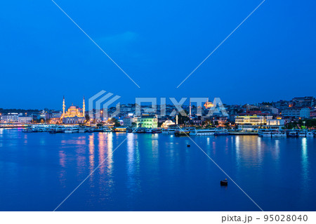 トルコ　イスタンブールの金角湾の夜景と旧市街にあるライトアップされたニューモスク 95028040