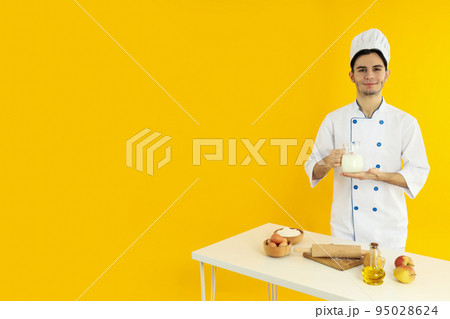 Concept of cooking, young man chef on yellow background 95028624