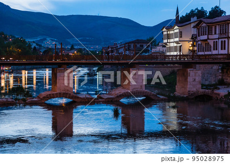 トルコ　夜のアマスィヤに流れるライトアップされたイェシル川と旧市街の街並み 95028975