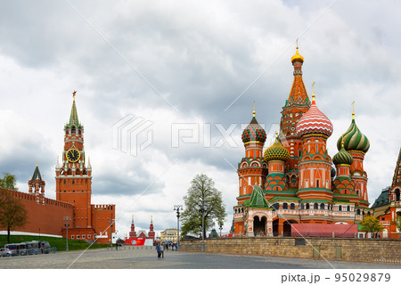 St. Basil's Cathedral on Red square and Moscow Kremlin with Spasskaya tower on a dramatic cloudy sky background. 95029879