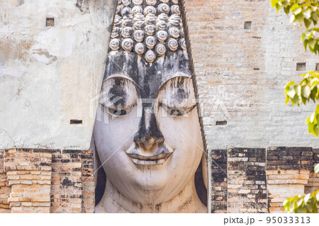 Close up of Buddha statue through the entrance gate at Sri Chum temple in Sukhothai Historic Park, a destination of tourist in Thailand 95033313