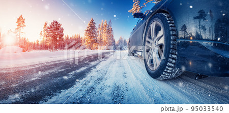 Closeup view of the car's wheel on the snowy road in natural park 95033540