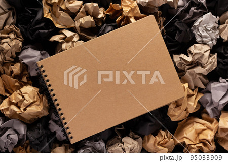 Notebook on crumpled paper balls as background texture. Inspiration idea concept Notebook on crumpled paper balls as background texture. Inspiration idea concept 95033909