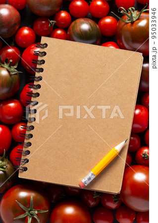 Blank recipe book and fresh tomato on table. Tomatoes with cookbook at tabletop top view 95033946