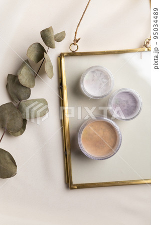 Top view eye shadow and facial powder on natural background with dried flowers. Aesthetics of makeup artist, make-up for yourself and beauty salon Top view eye shadow and facial powder on natural background with dried flowers. Aesthetics of makeup artist, make-up for yourself and beauty salon 95034489