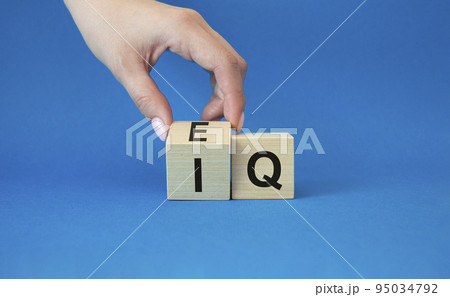 IQ or EQ symbol. Businessman hand turns cube with words IQ, intelligence quotient to EQ, emotional quotient. Beautiful blue background. Emotional and intelligence quotient concept. Copy space. IQ or EQ symbol. Businessman hand turns cube with words IQ, intelligence quotient to EQ, emotional quotient. Beautiful blue background. Emotional and intelligence quotient concept. Copy space. 95034792