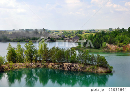Drowned basalt quarry with stone mining works on the background Drowned basalt quarry with stone mining works on the background 95035644