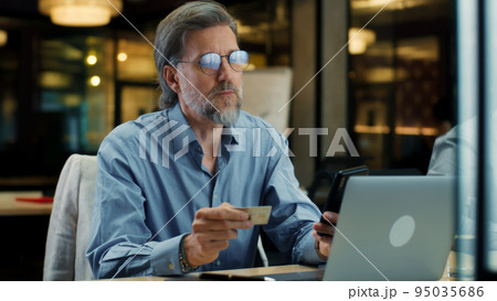 Man transferring money during office work 95035686