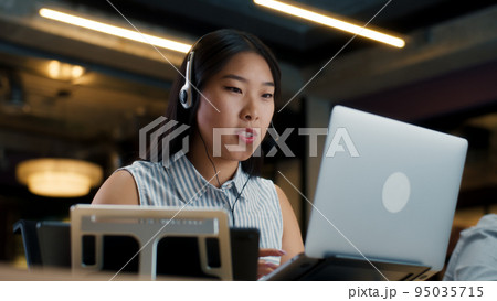 Female office worker talking with client online Female office worker talking with client online 95035715