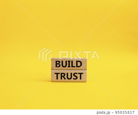 Build trust symbol. Wooden blocks with words Build trust. Beautiful yellow background. Business and Build trust concept. Copy space. 95035817