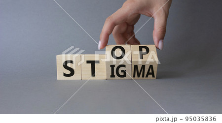 Stop and Stigma symbol. Concept words Stop and Stigma on wooden cubes. Beautiful grey background. Businessman hand. Business and Stop and Stigma concept. Copy space. 95035836