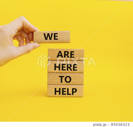 We are here to help symbol. Concept words we are here to help on wooden blocks. Beautiful yellow background. Business and we are here to help concept. Copy space. 95036323