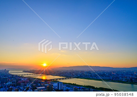 沈み行く夕陽に照らされる大阪の街並みと淀川【大阪風景】 95038548