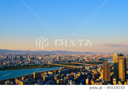 沈み行く夕陽に照らされる大阪の街並みと淀川【大阪風景】 95038550