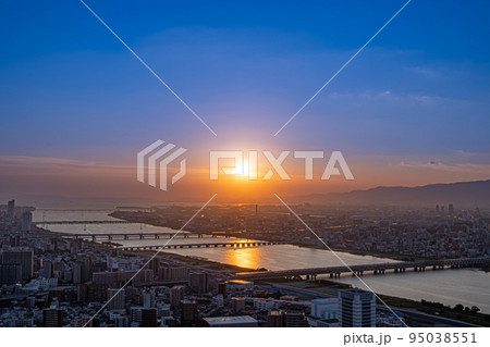 沈み行く夕陽に照らされる大阪の街並みと淀川【大阪風景】 95038551